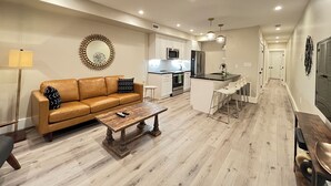 Um apartamento moderno com sala de estar, cozinha e área de jantar.