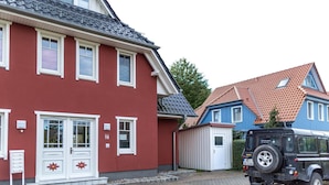 A red building with white trim and a garage. - Mühlenstr. 19 Wg.2, Deutschland (Zingst)