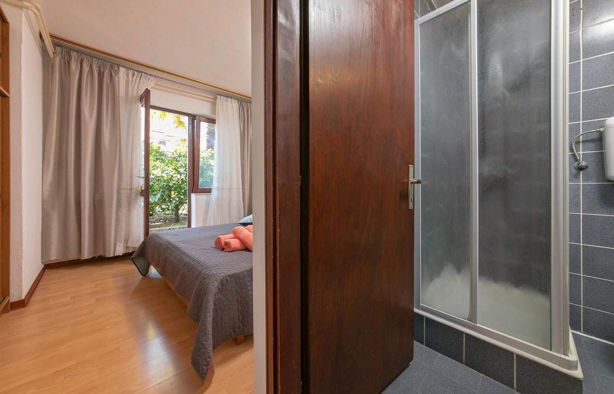 Une chambre avec un lit, une douche et une vue sur la verdure.