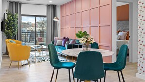 Una sala moderna con un sofá, sillones, una mesa de centro y un comedor.