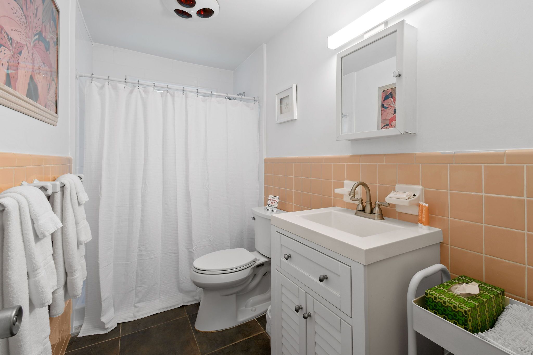 Een badkamer met toilet, wastafel en douchegordijn.