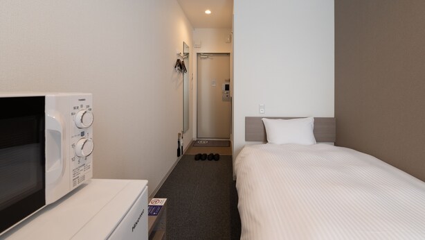 A hotel room with a bed, a microwave, and a small kitchenette. - HOTEL R9 The Yard Nagahama (Nagahama)