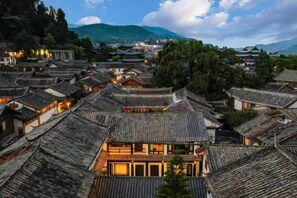 A traditional village with multiple buildings featuring tiled roofs and wooden structures.