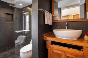 A modern bathroom with a glass-enclosed shower, a white toilet, and a wooden vanity with a large sink. - Lijiang Houfu Inn (Lijiang)