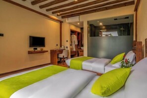 Habitació d'hotel amb dos llits, televisió, escriptori i armari.