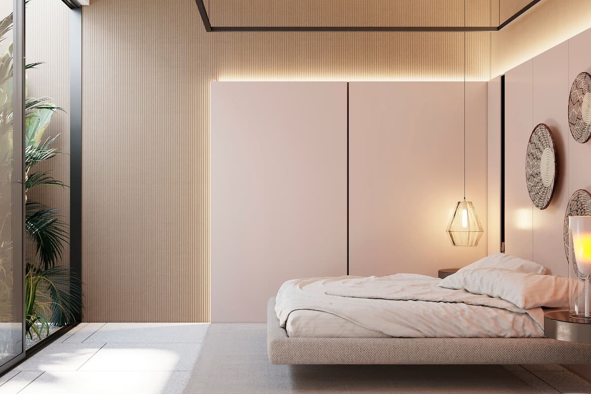 A modern bedroom with a bed, bedside table, lamp, and decorative wall art.