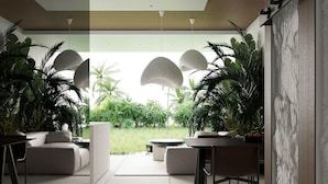 A modern interior with a central seating area, a dining table, and potted plants. - Green Flow Villa 2 (Ubud)