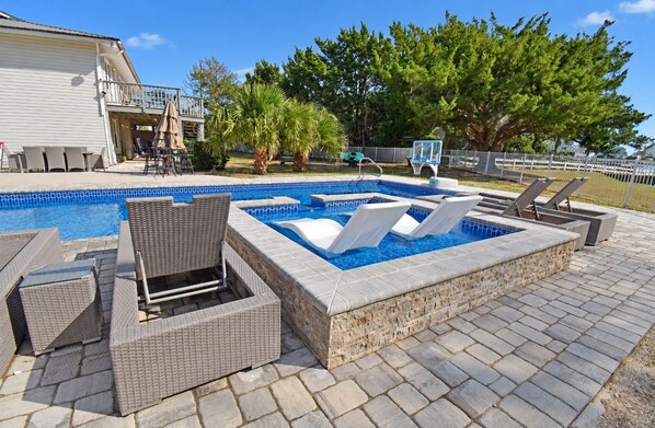 A swimming pool with lounge chairs and a hot tub area. - Game Time - Channel Front in Garden City Beach (Garden City Beach)