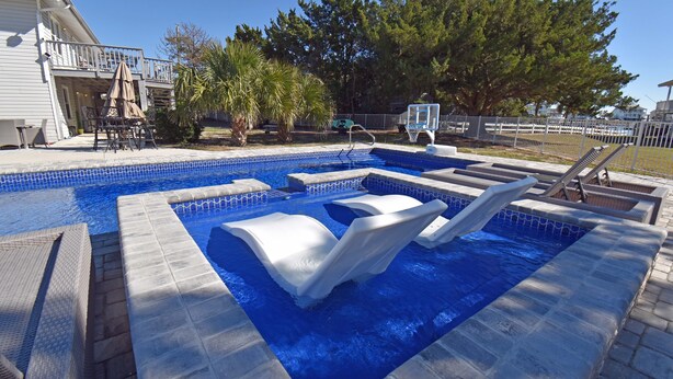 A swimming pool with a hot tub, lounge chairs, and a small deck area. - Game Time - Channel Front in Garden City Beach (Garden City Beach)