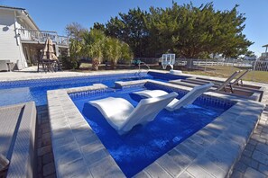A swimming pool with a diving board and lounge chairs. - Game Time - Channel Front in Garden City Beach (Garden City Beach)