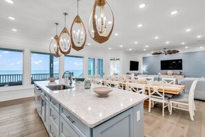 A spacious kitchen with a large island, modern pendant lights, and a view of the ocean. - Jonesin' By The Beach - Ocean Front & Channel Front in Garden City Beach (Garden City Beach)