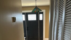 A hallway with wooden flooring, a black door with a welcome mat, and a ceiling fan. - Out in Left Field Home in Country Farm setting  (Laurens)