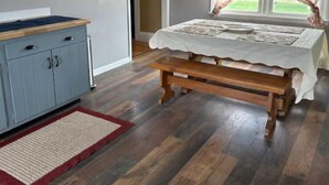 A bedroom with a wooden bed, a blue cabinet, and a red rug. - Out in Left Field Home in Country Farm setting  (Laurens)