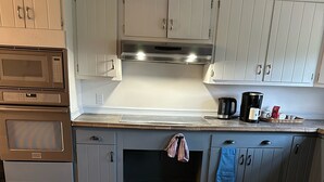 A kitchen with a microwave, oven, and a coffee maker on the counter. - Out in Left Field Home in Country Farm setting  (Laurens)