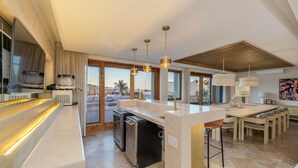 Cocina moderna con isla central, electrodomésticos integrados y vistas a la ciudad.