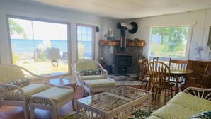 Un salón acogedor con muebles de mimbre, una mesa de centro de vidrio y una chimenea.