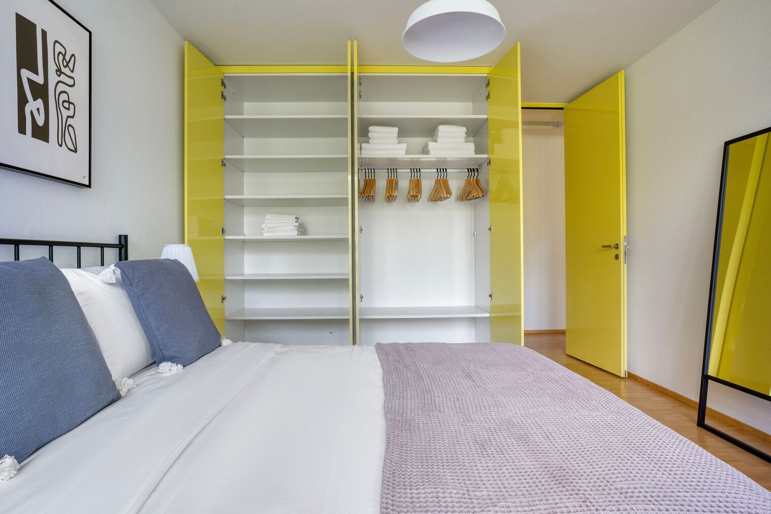 Een slaapkamer met een bed, een kledingkast en een deur.