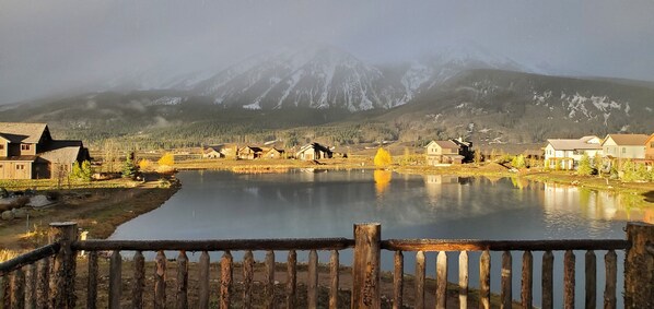 Vista de un lago con casas y una montaña al fondo.