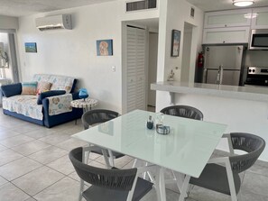 A modern kitchen with white cabinets, a stainless steel refrigerator, and a microwave.