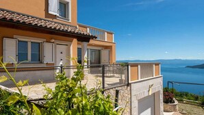 A two-story building with a balcony overlooking a body of water. - Stunning home in Brsec with sauna (Brsec)