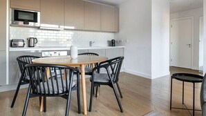 Une cuisine moderne avec un coin repas, comprenant un four à micro-ondes Bosch, un grille-pain et une bouilloire.