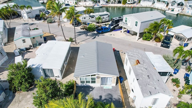 A residential area with houses, a marina, and a blue truck parked in front of a house with a sloped roof. - Venture Out 2 Bedroom (Cudjoe Key)
