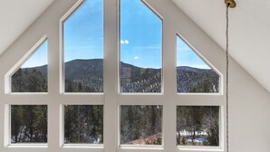 Une pièce dotée de grandes fenêtres donnant sur un paysage montagneux.