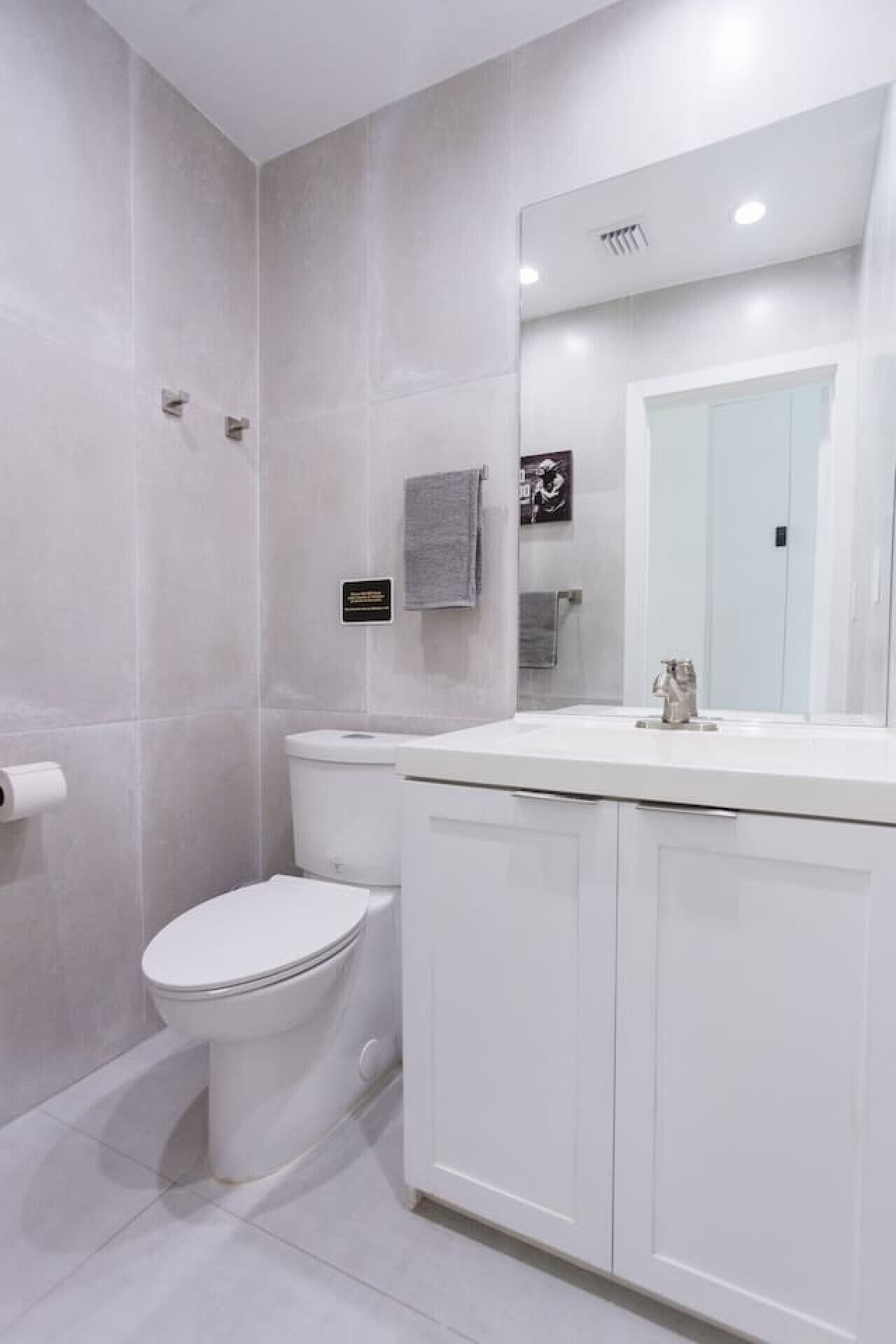 Une salle de bain moderne avec des toilettes, un lavabo et un miroir.