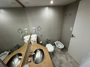 Casa de banho moderna com duas pias, sanita, bidé e chuveiro.