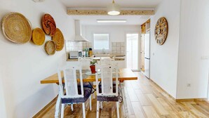 Une cuisine moderne avec des armoires blanches, un plan de travail en bois et un luminaire suspendu.