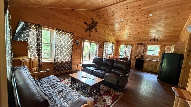 Ein Ferienhaus-Innenraum mit Wohnbereich, Essbereich und Küche.