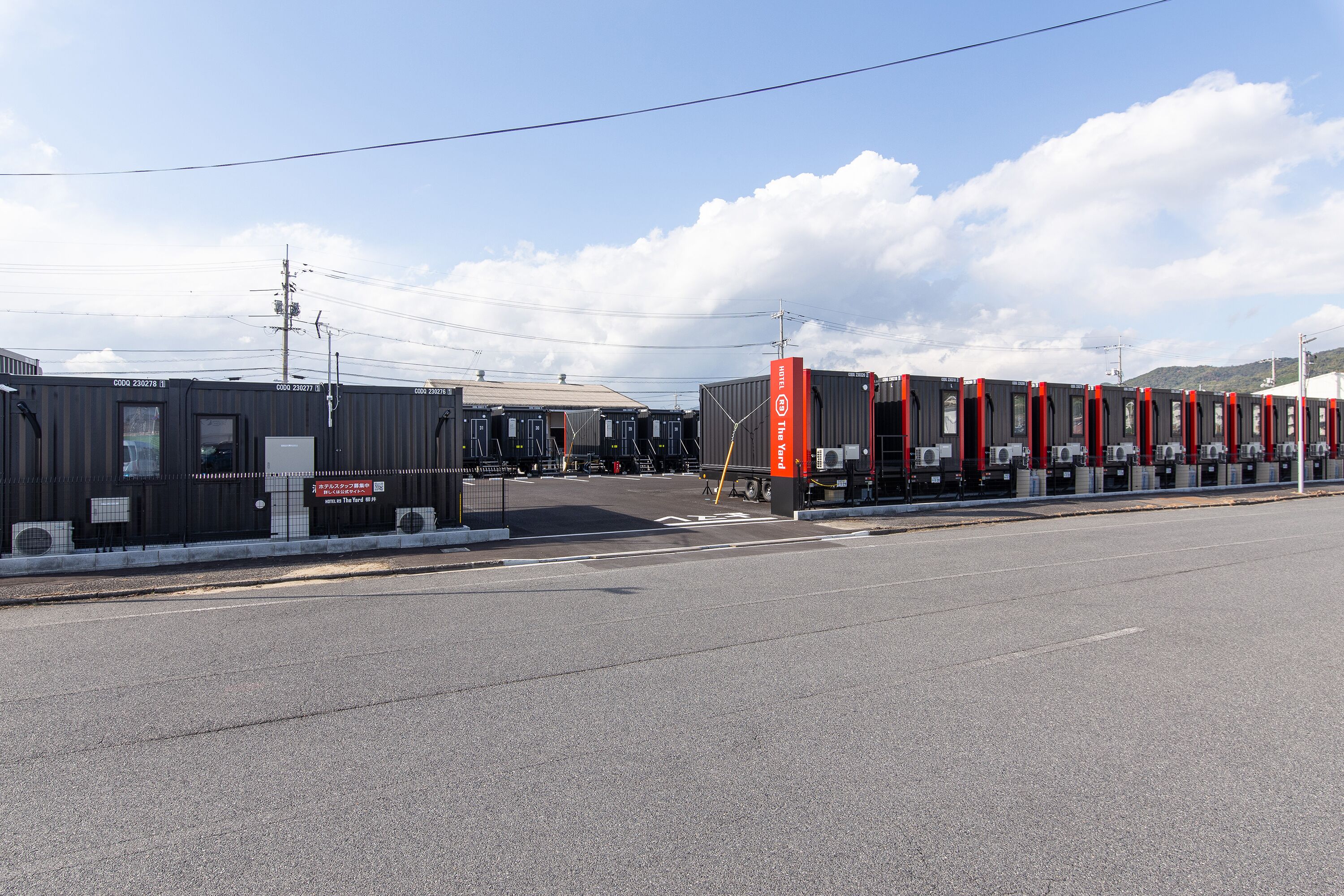 A shipping container building with a loading dock and a road in front.