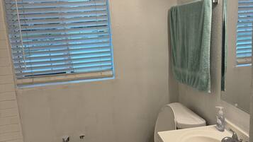 Kombinasi shower/bathtub, pancuran hujan, handuk, dan tisu toilet