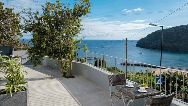 A terrace with a view of the sea, a table with chairs, and a potted plant. - GuestReady - Machico sea view residence - A (Machico)