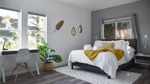 A bedroom with a bed, a desk, a chair, a potted plant, and a window with curtains. - NEW Colorful + Spacious 3BD/2BA Home in the ❤️of Mill Valley
- Fully remodeled  (Mill Valley)