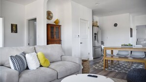 A modern living room with a grey sofa, a small round table, and a dining area with a wooden table and chairs. - NEW Colorful + Spacious 3BD/2BA Home in the ❤️of Mill Valley
- Fully remodeled  (Mill Valley)