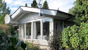 Een huis met een schotelantenne, grote ramen en een tuin.