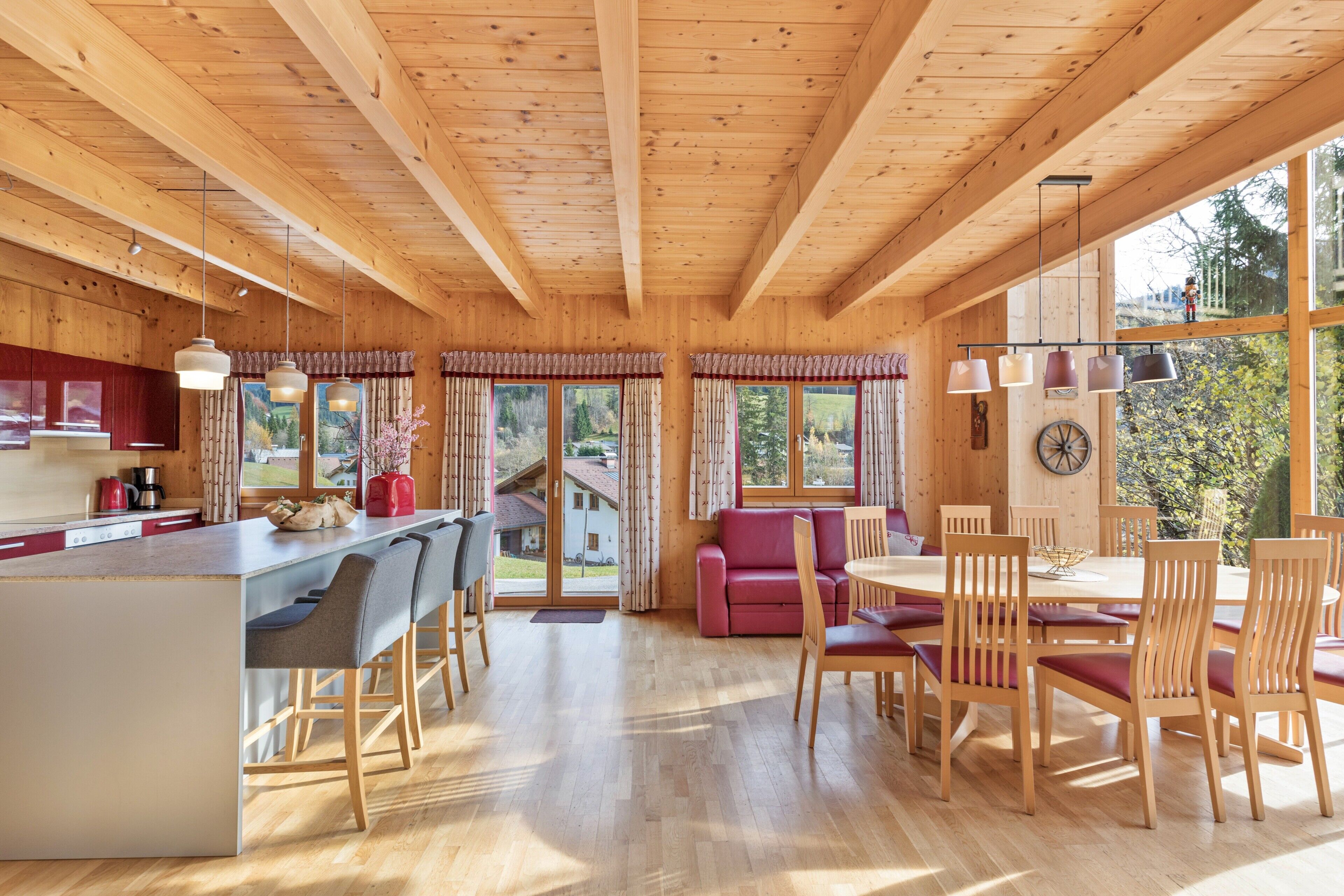 Ein Holzblockhaus-Interieur mit Küche, Essbereich und großen Fenstern.
