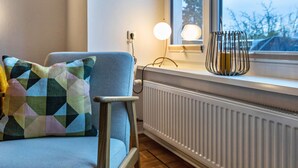 A room with a radiator, a window with a view, a chair, and a cushion. - Apartment 'Apartement Hangarstein' with Balcony and Wi-Fi (Kassel)