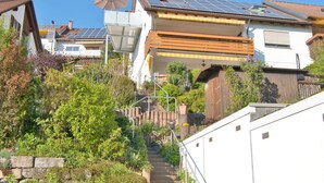 A residential building with solar panels, a balcony, and a staircase leading to the entrance. - Apartment 'Seerose' with Shared Garden, Balcony and Wi-Fi (Überlingen)