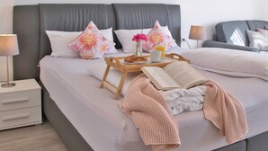 A neatly made bed with pillows, a tray with breakfast, a book, and a blanket. - Apartment 'Seerose' with Shared Garden, Balcony and Wi-Fi (Überlingen)
