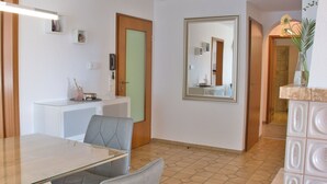 A modern hotel room with a dining area, a large mirror, and a bathroom visible through an open door. - Apartment 'Seerose' with Shared Garden, Balcony and Wi-Fi (Überlingen)
