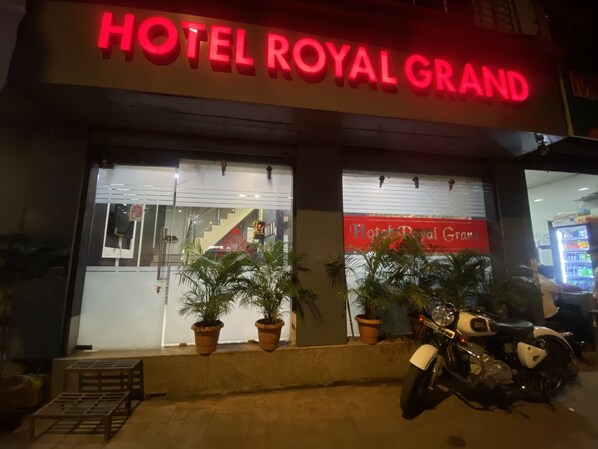 Das Hotel Royal Grand mit auffälligem roten Schriftzug, Blumentöpfen und einem draußen abgestellten Motorrad.
