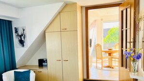 Une chambre d’hôtel équipée d’un lit, d’un bureau, d’une chaise, d’une armoire et offrant une vue sur l’extérieur.
