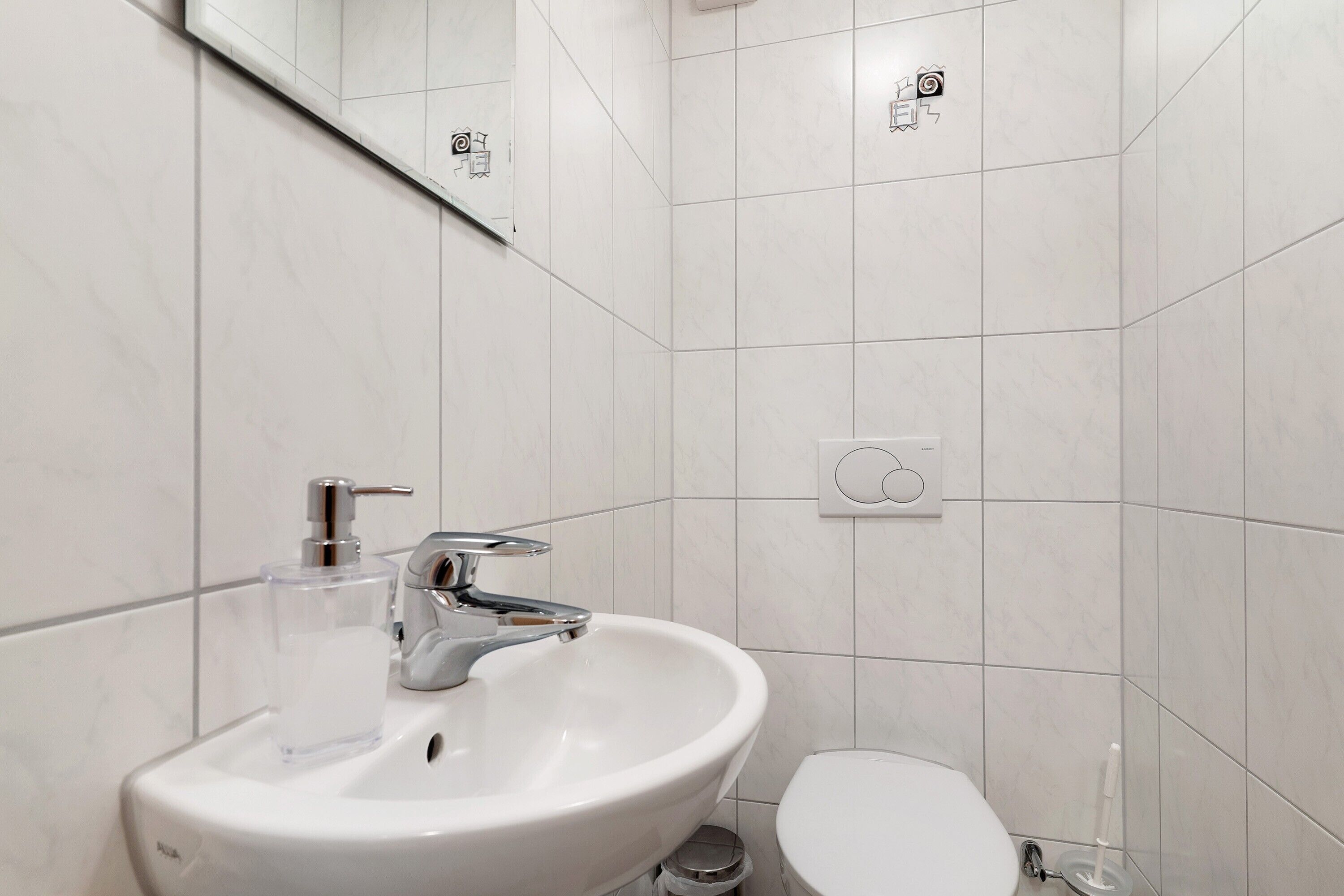 Un baño con un lavabo blanco, un inodoro y un espejo.