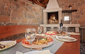 A dining table set for a meal with plates of food, wine glasses, and a bottle of wine.