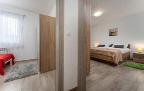 Ein Schlafzimmer mit Bett, Nachttisch, Lampe und einer roten Bank.