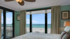 A bedroom with a large bed, a ceiling fan, a view of the beach, and a balcony. - Watercrest 203 - FREE Beach Chairs! (Panama City Beach)