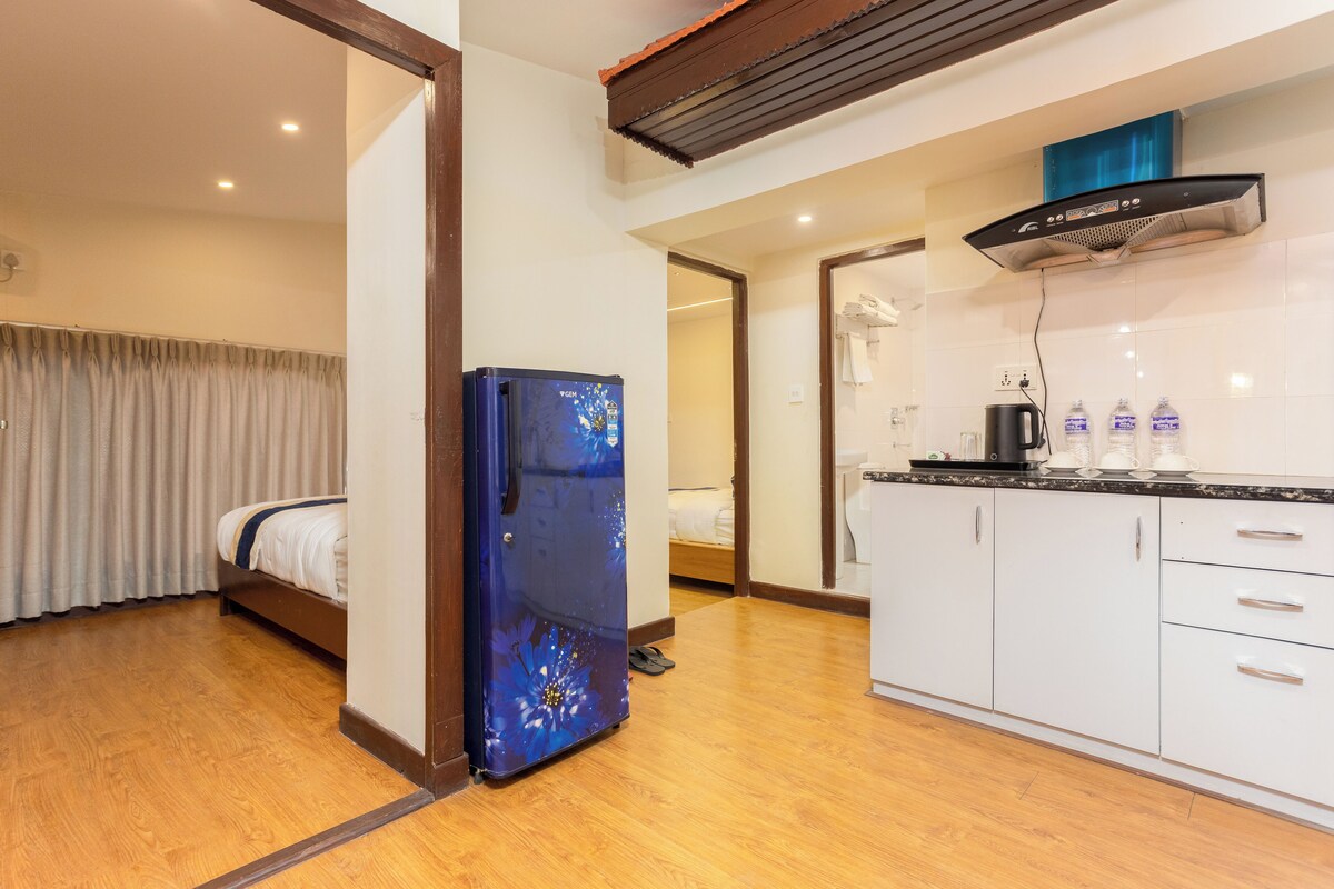 Habitación de hotel con cama, refrigerador, kitchenette y baño.