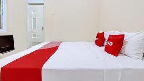 Una habitación de hotel con una cama, un televisor y una puerta.